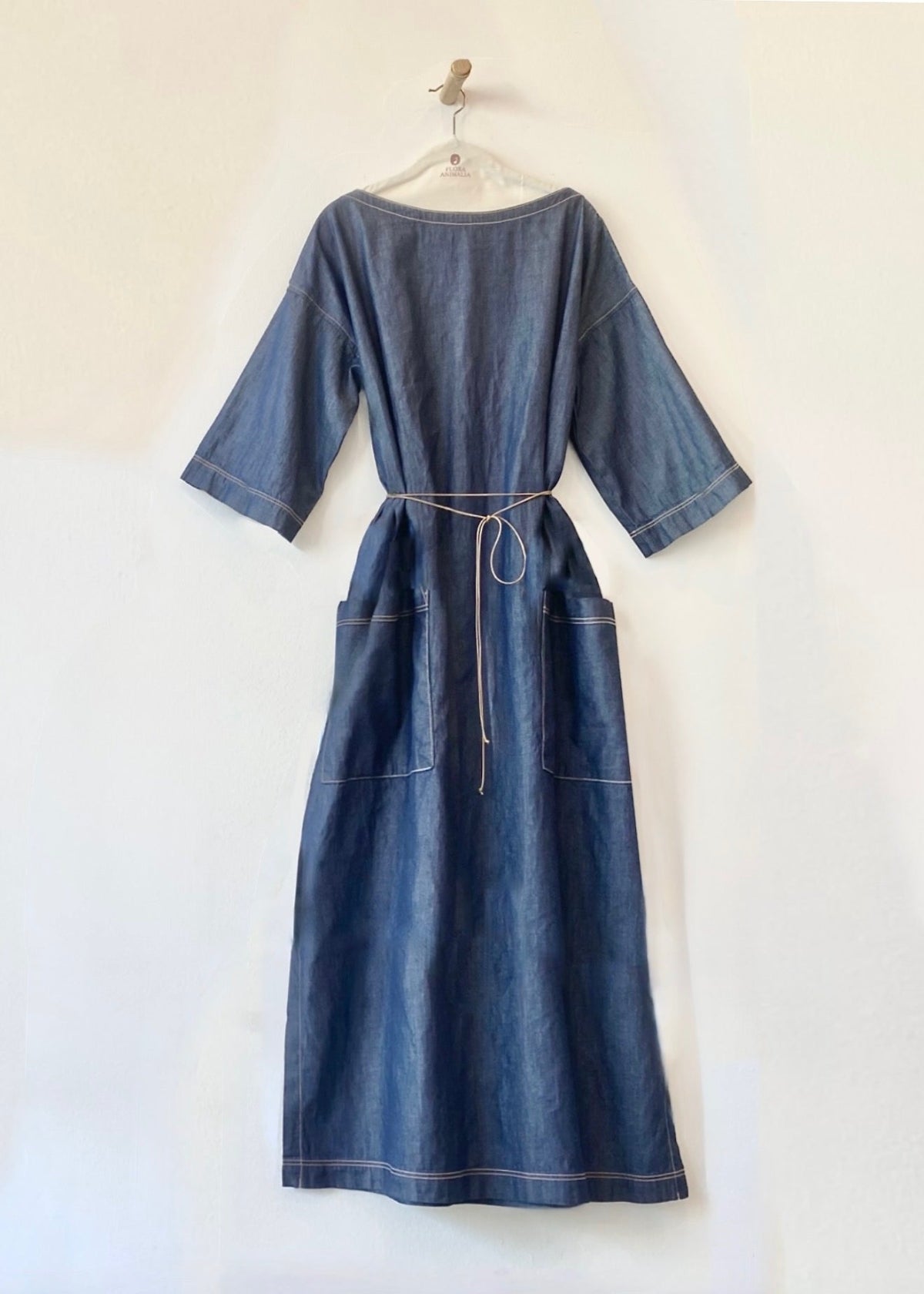 belted Denim urban garden dress on a hanger against a white background