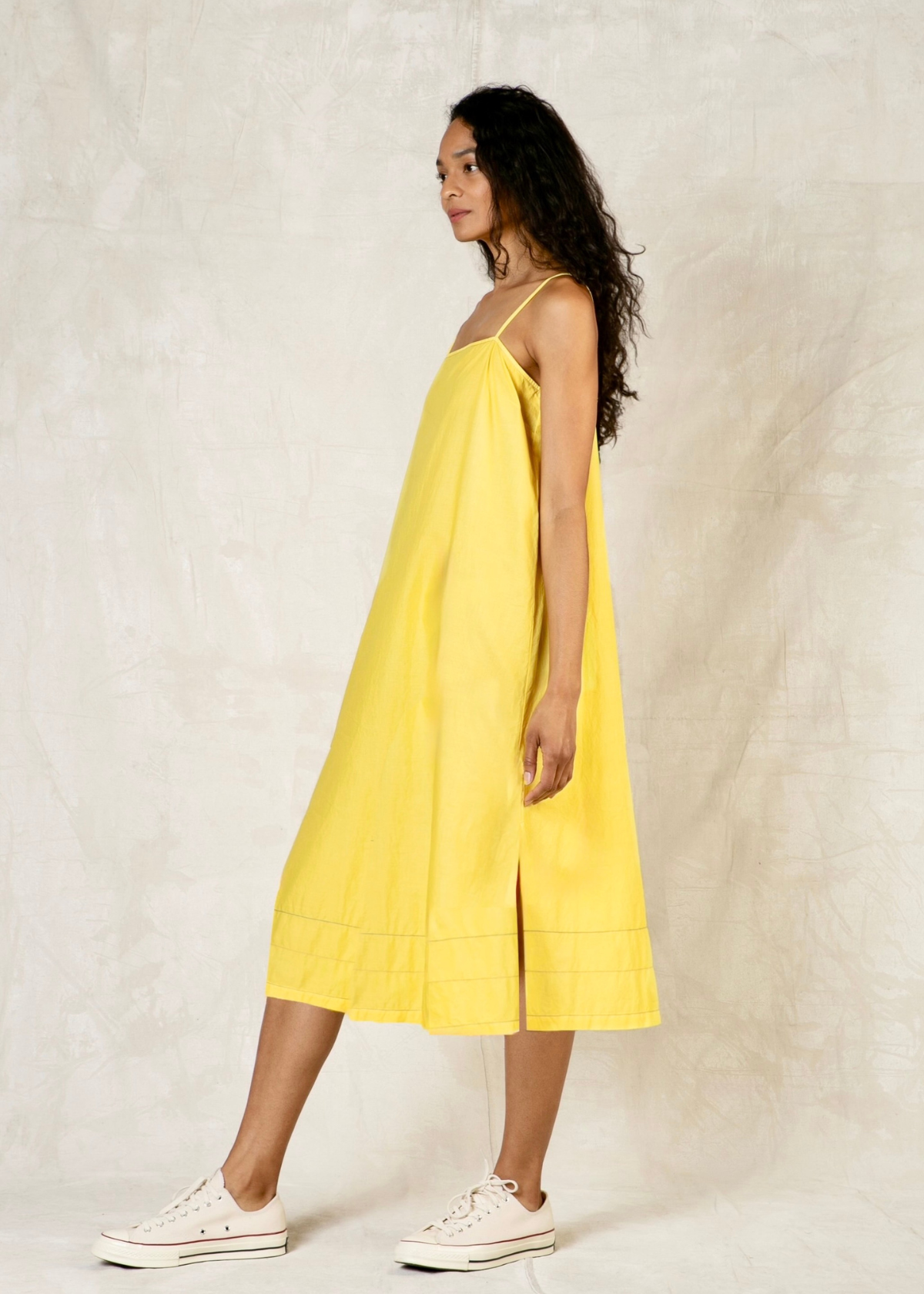 Woman wearing a yellow dress against a plain background