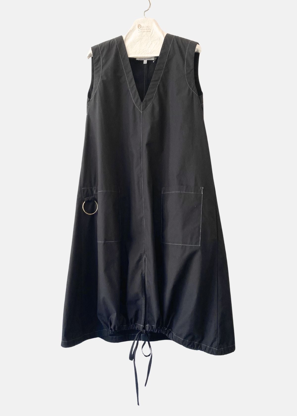 Black sleeveless dress on a hanger against a white background