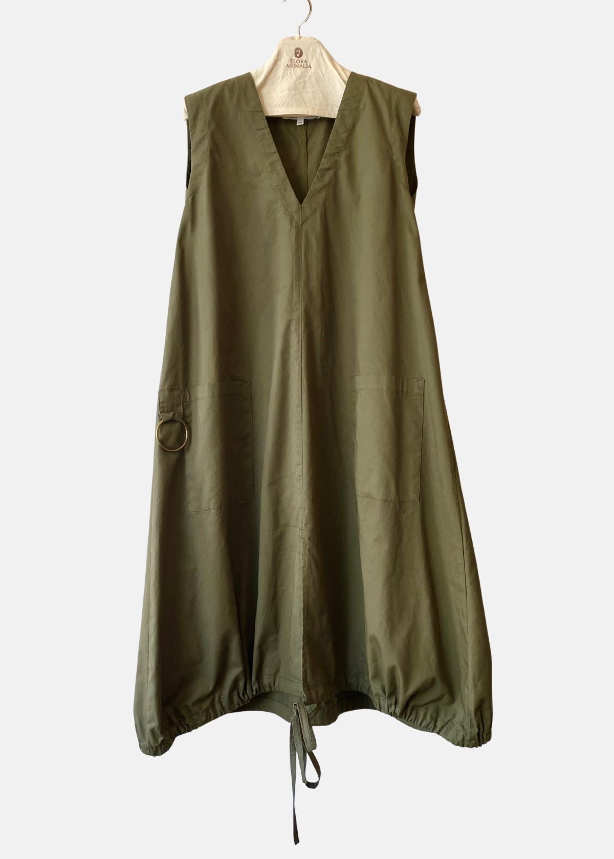 Green sleeveless dress on a hanger against a white background