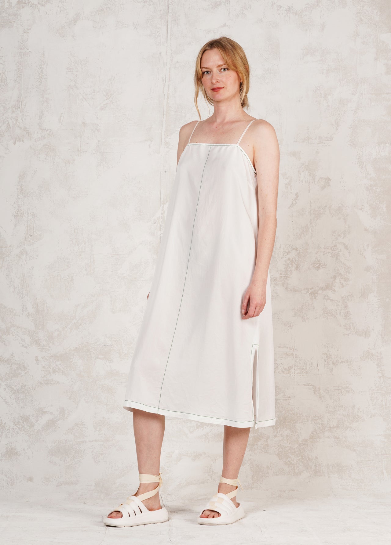 white spaghetti strap dress against neutral wall
