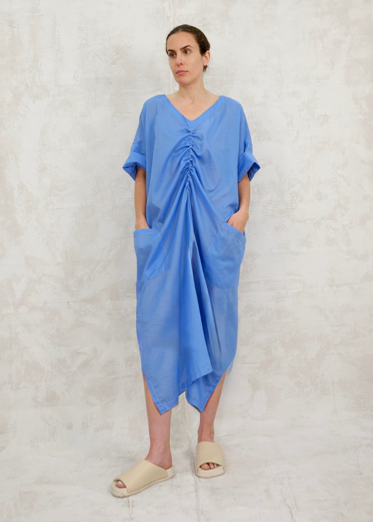 Woman wearing a blue dress against a light gray background