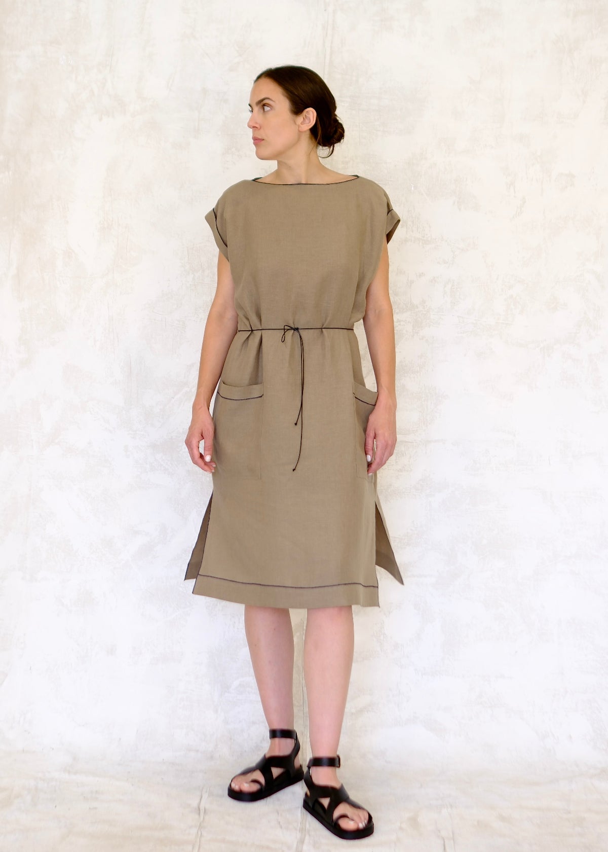 model in khaki colored linen sheath dress belted with cotton cord