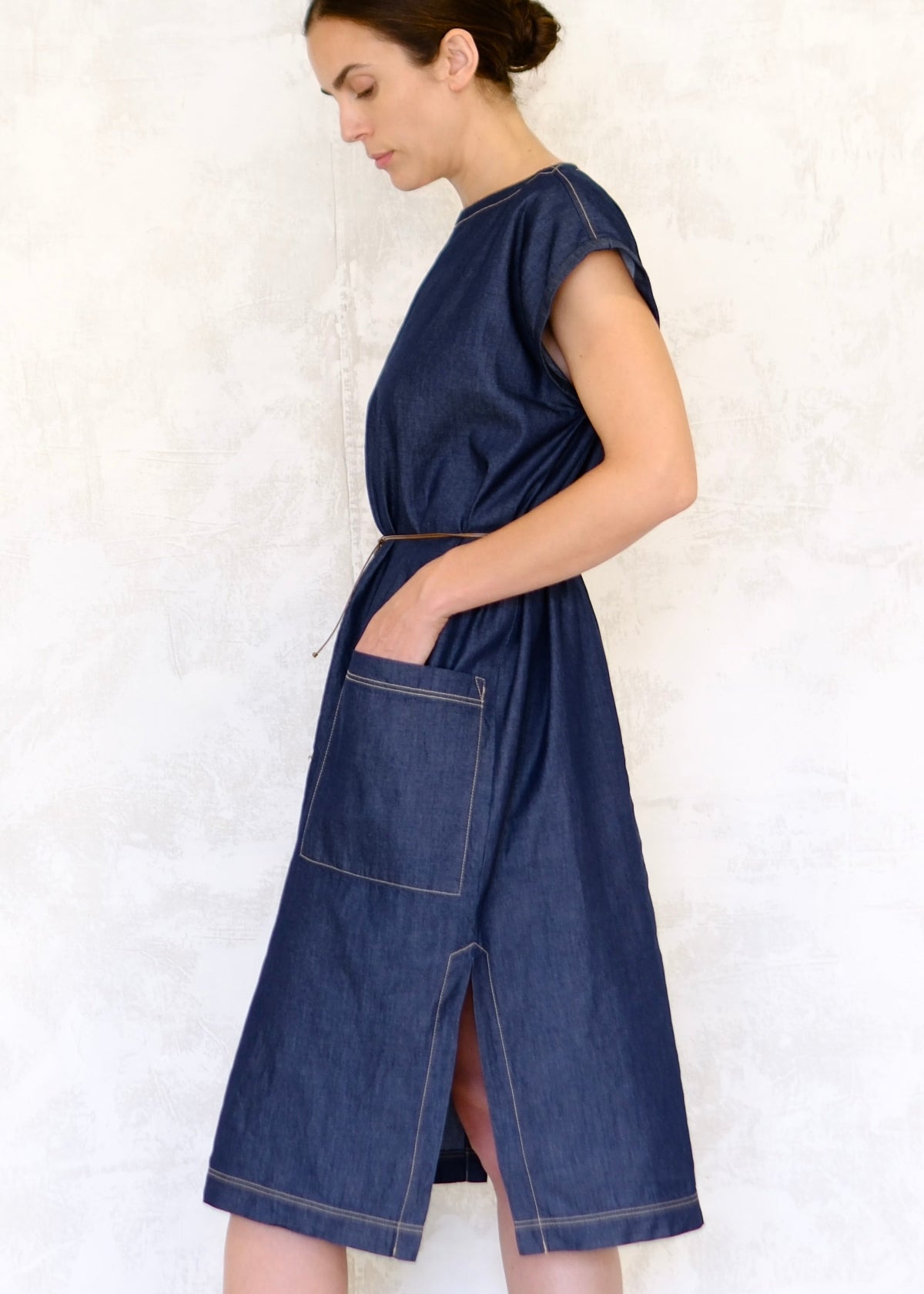 belted denim boat neck dress with hand in dress side view