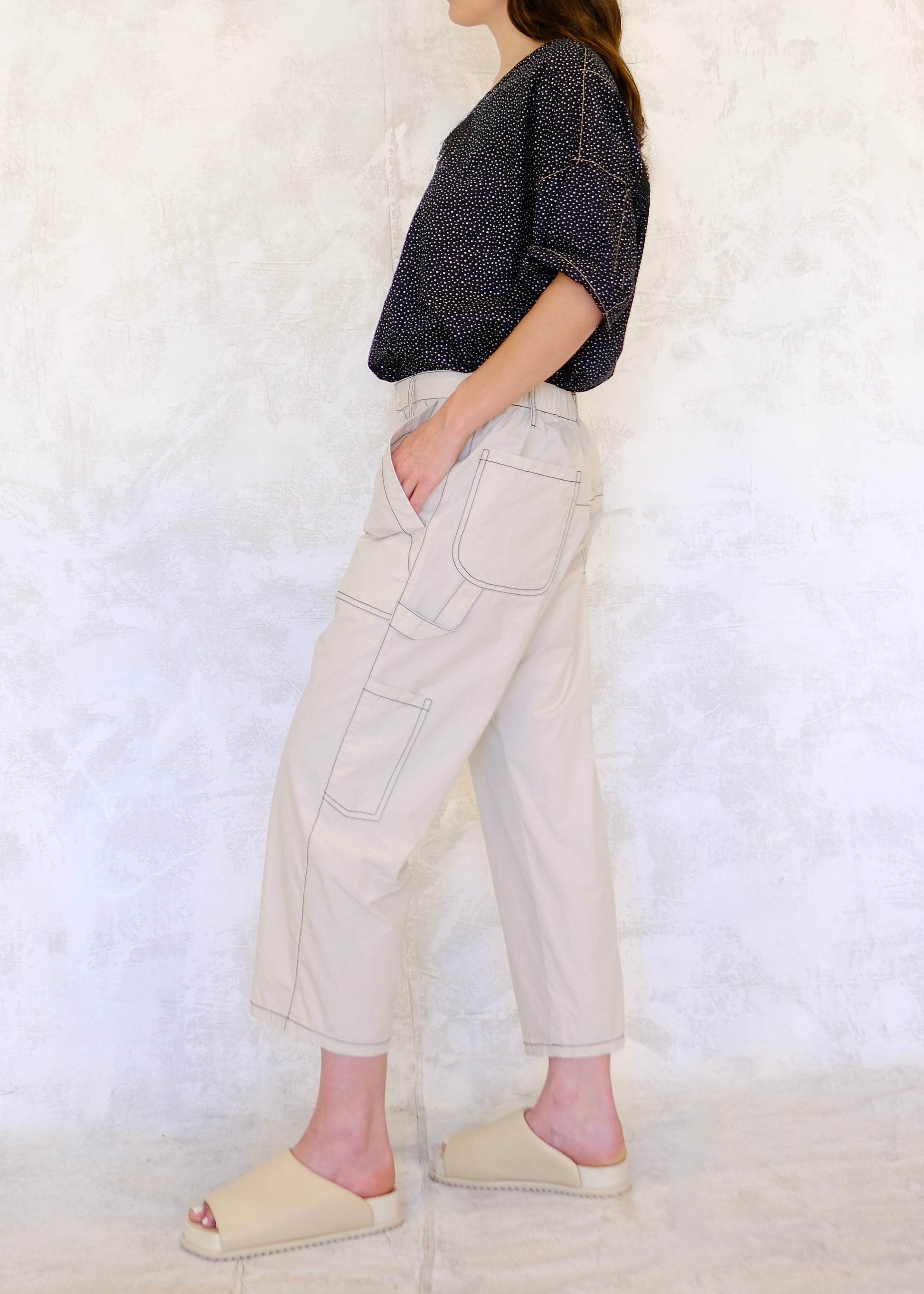 side view white color poplin pants with large front pockets, polka dot shirt