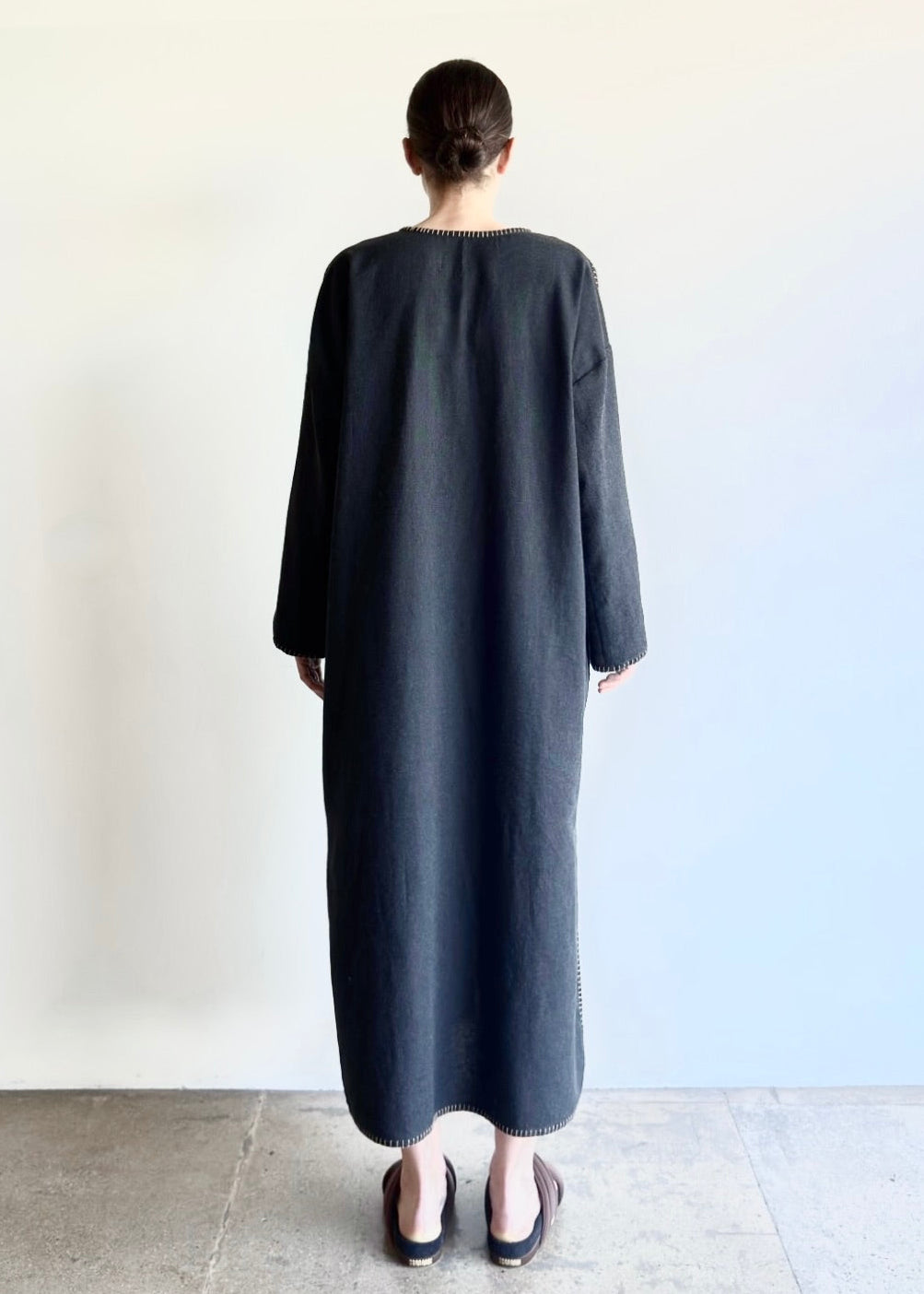 Back view of the Flannel Poet Dress, highlighting its long, uninterrupted line and gentle drape.