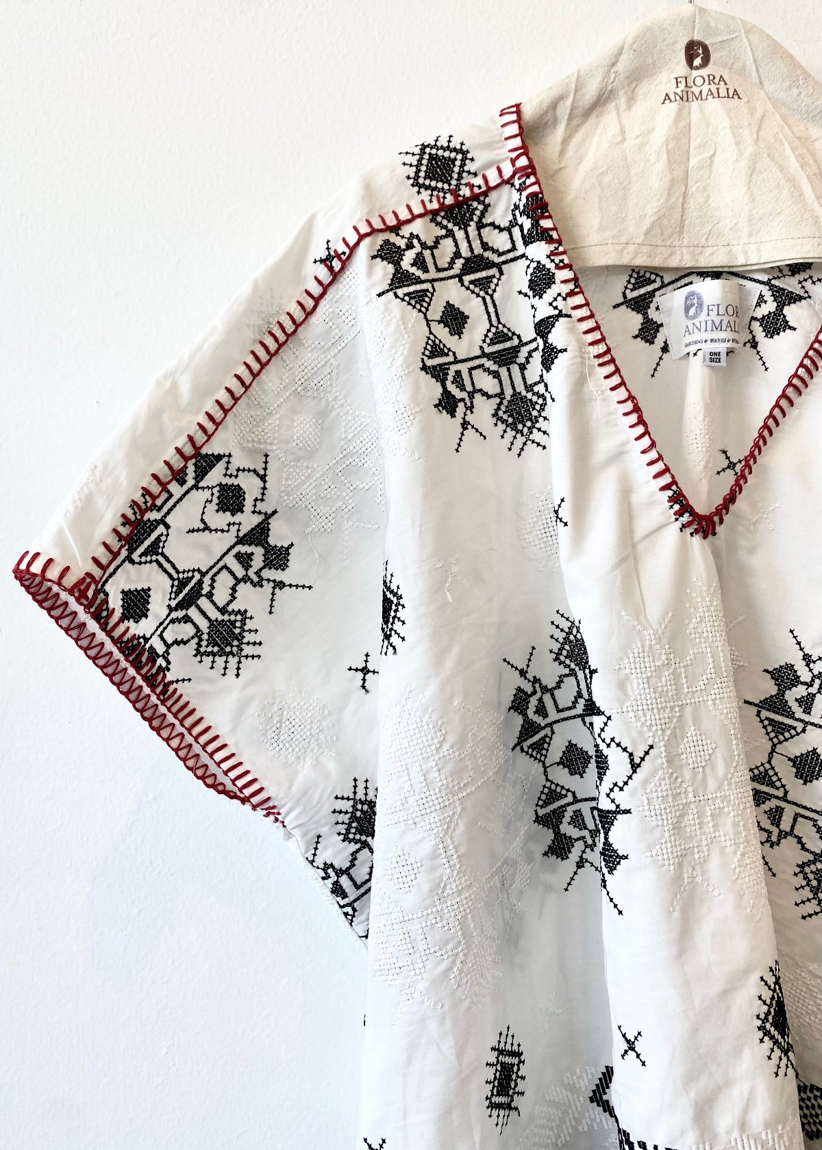 detail image white embroidered tunic with red blanket stitching short sleeves