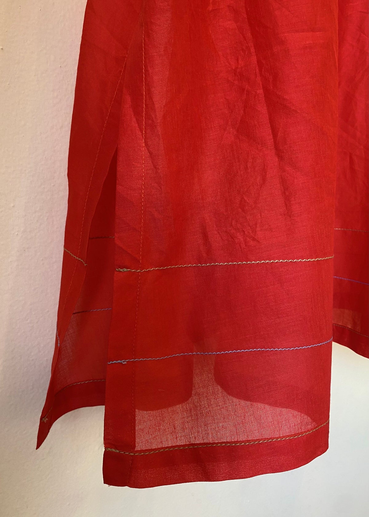 Red fabric with contrasting stitching and a plain background