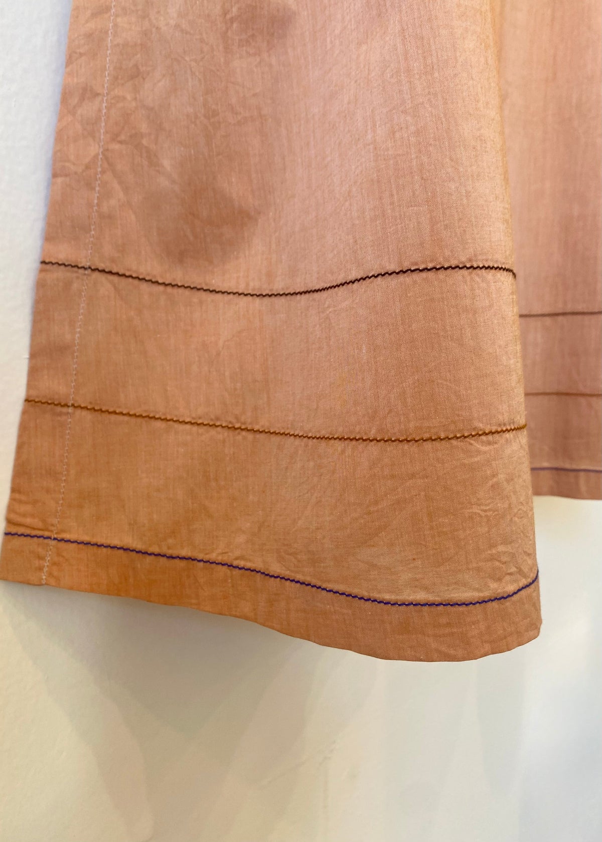 Close-up of a brown fabric with visible stitching on a white background