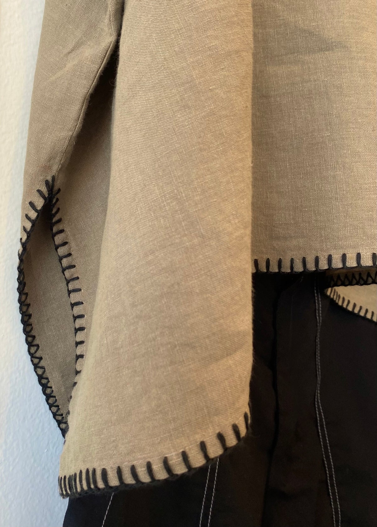 Close-up of a beige fabric with black stitching detail