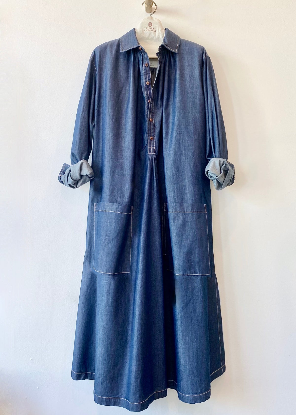 Blue denim Agnes dress with open collar and rolled sleeves on a white background