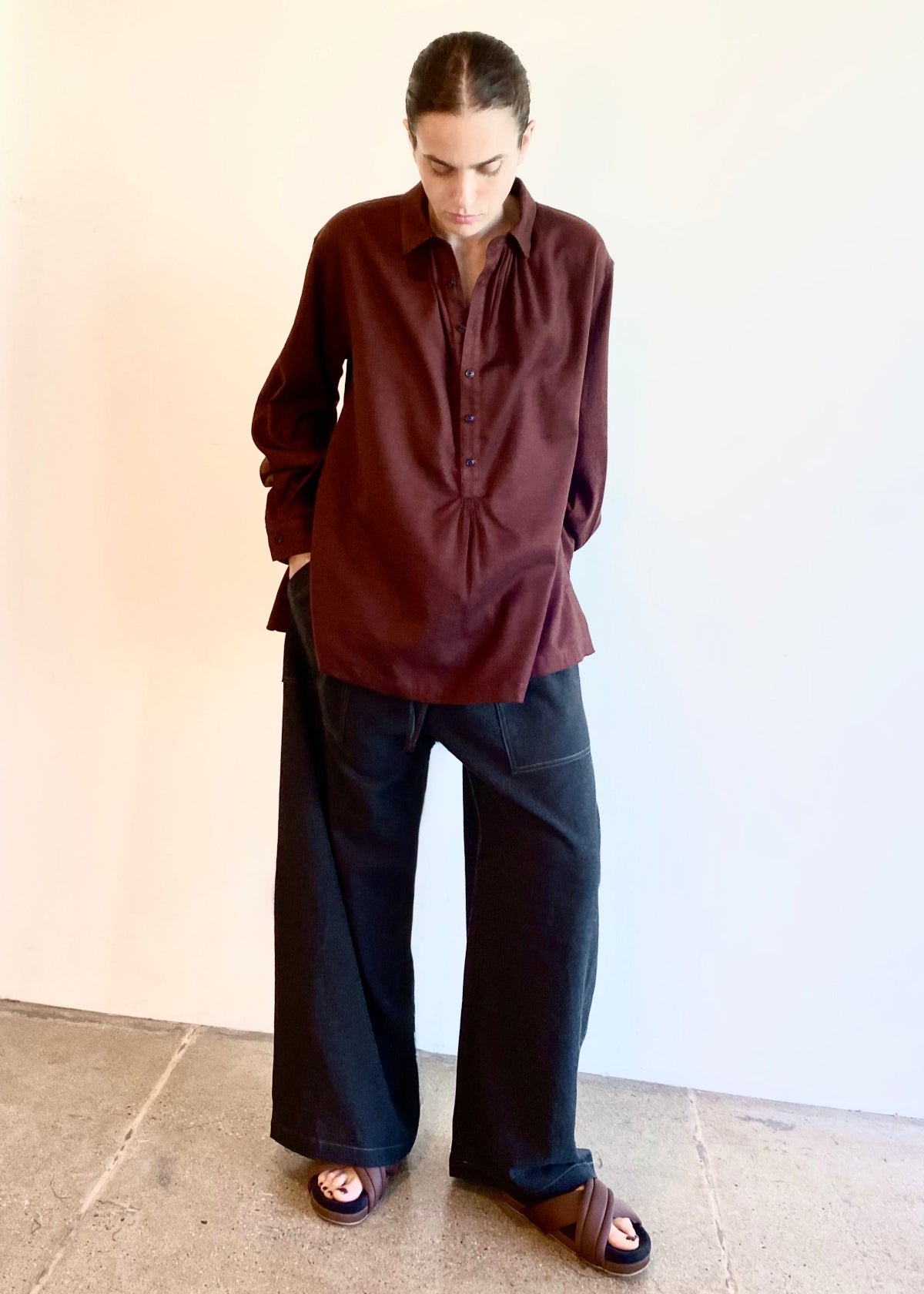 Person wearing a wine Agnes shirt and dark Picker's pants against a plain background