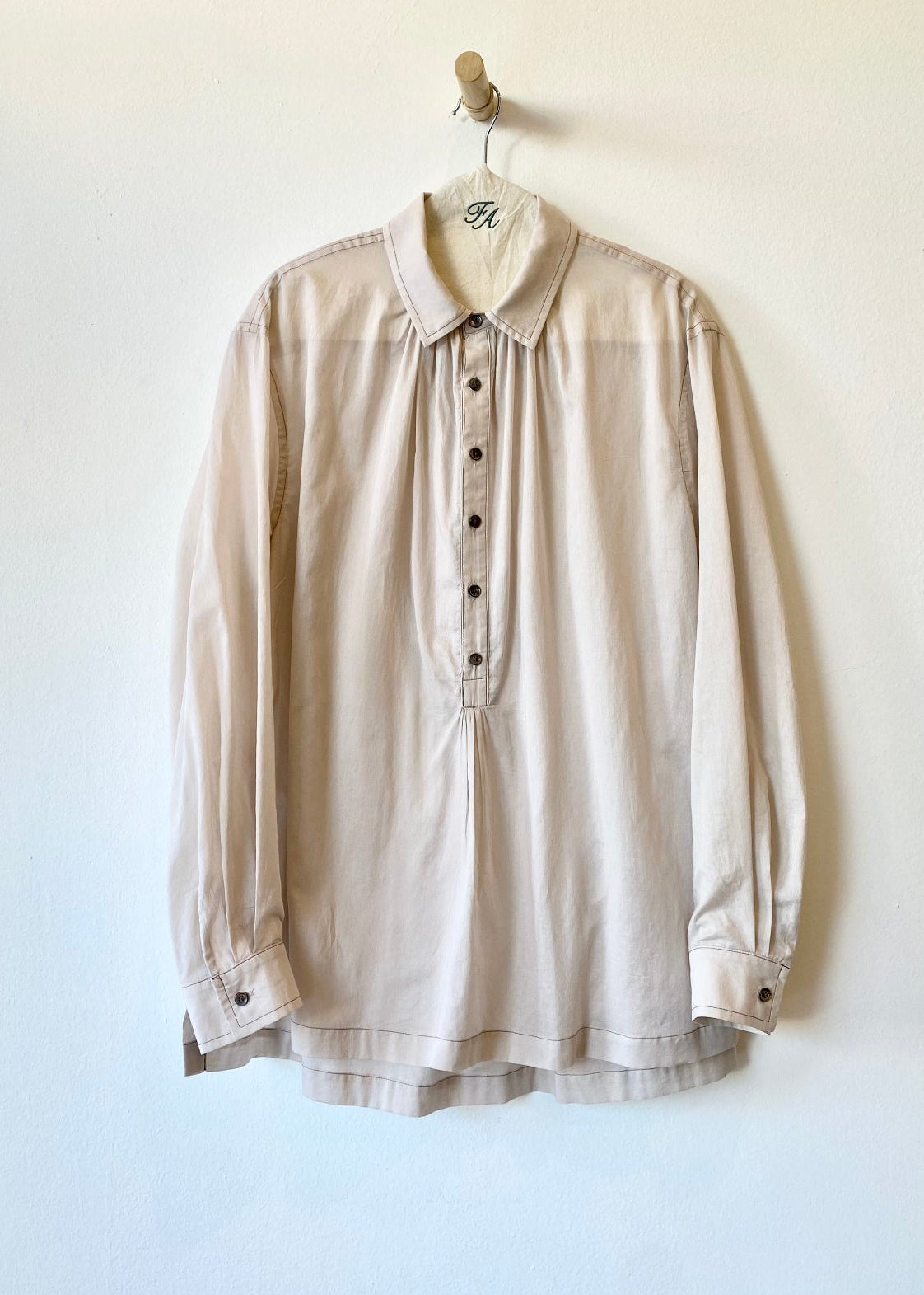 Green Agnes shirt on a hanger against a white background