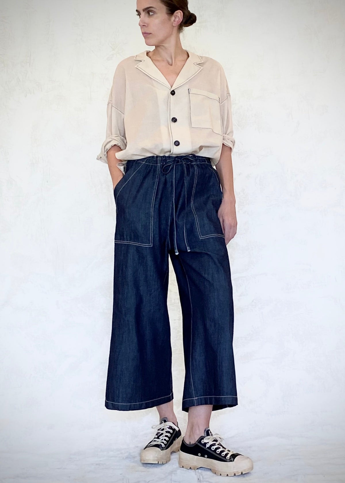 denim drawstring jeans with beige button down top tucked in