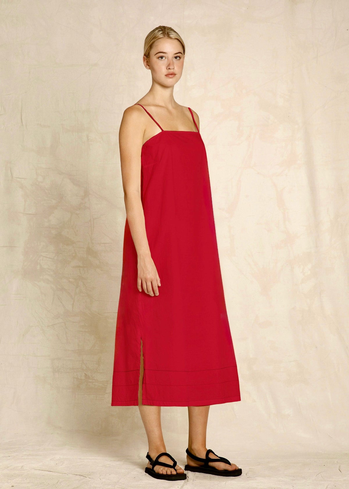 Woman wearing a red dress against a plain background