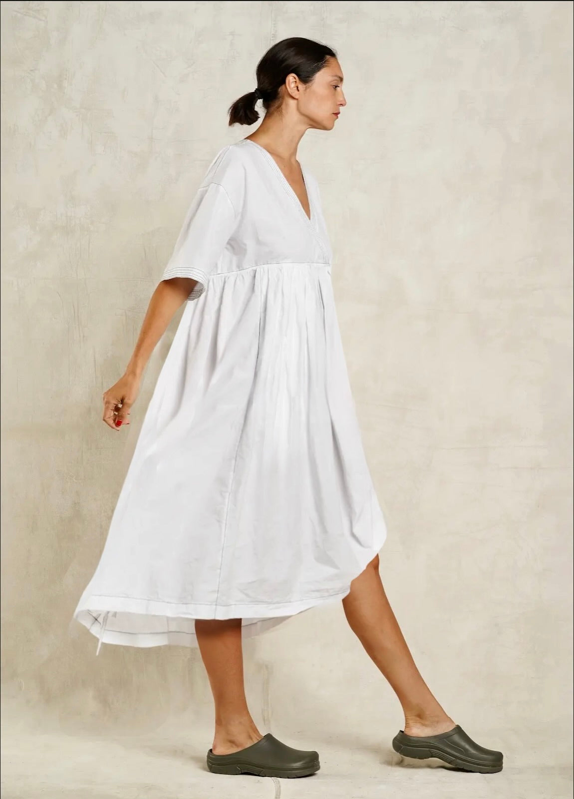 Woman wearing a white dress against a plain background