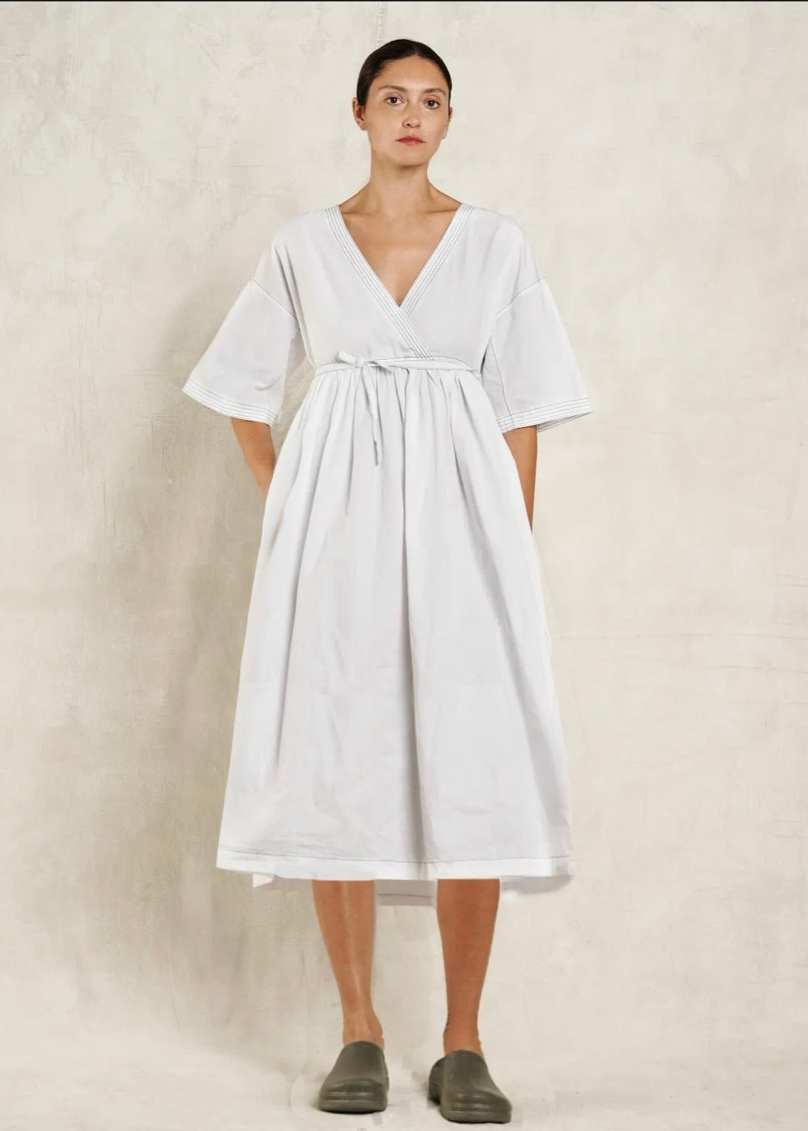 Woman wearing a white dress against a plain background