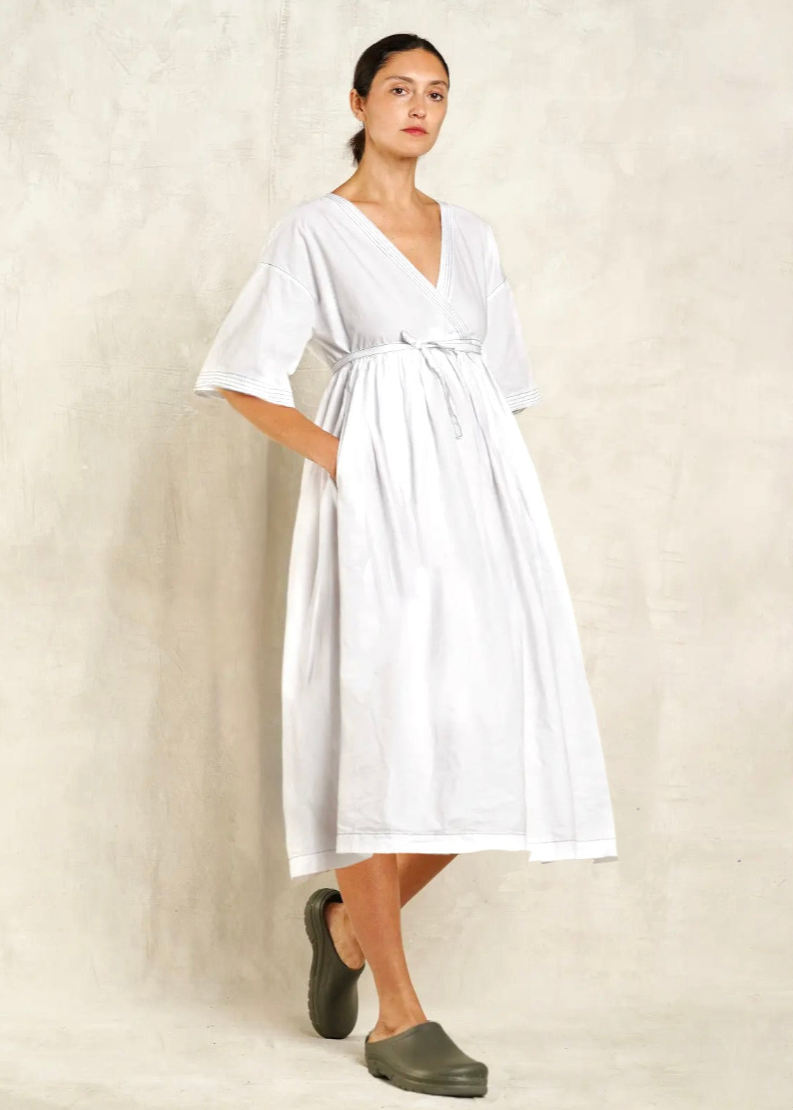 Woman wearing a white dress with a plain background