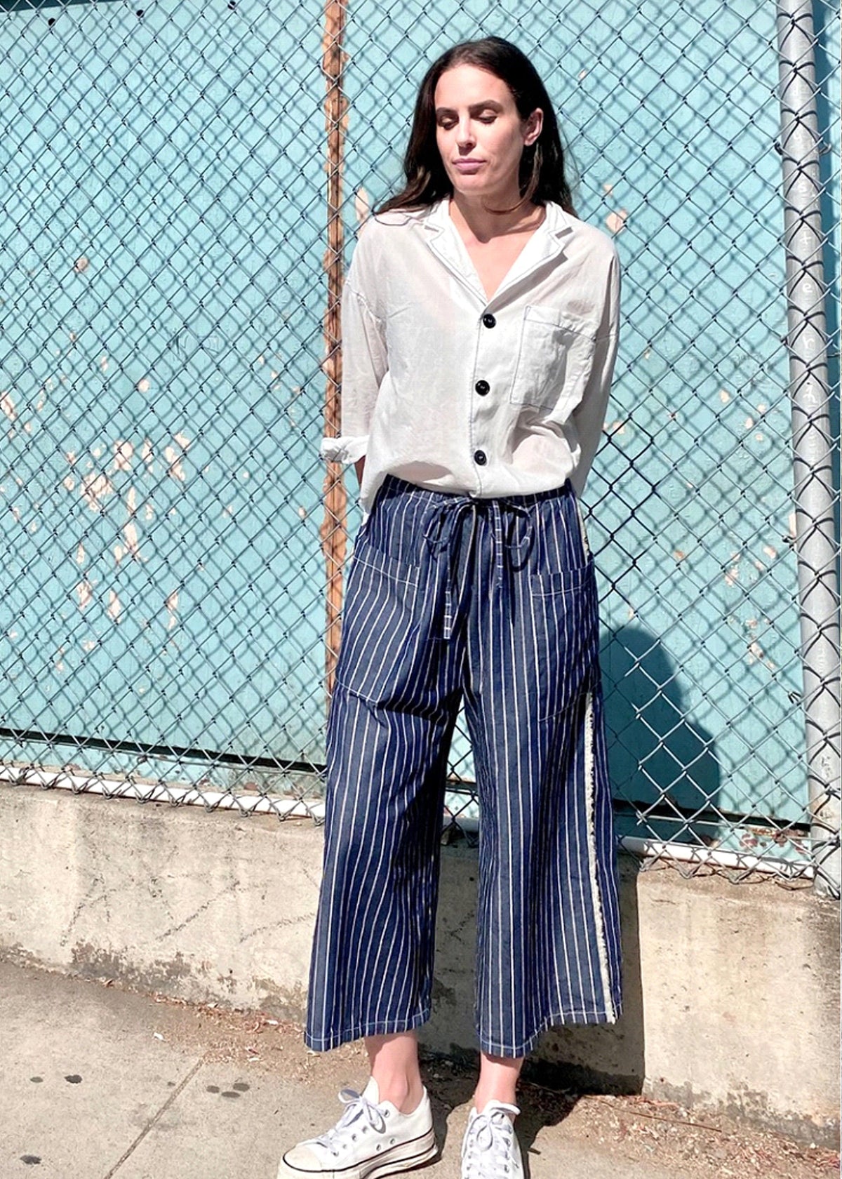 blue and white striped denim cropped drawstring picker's pants with white button down top.
