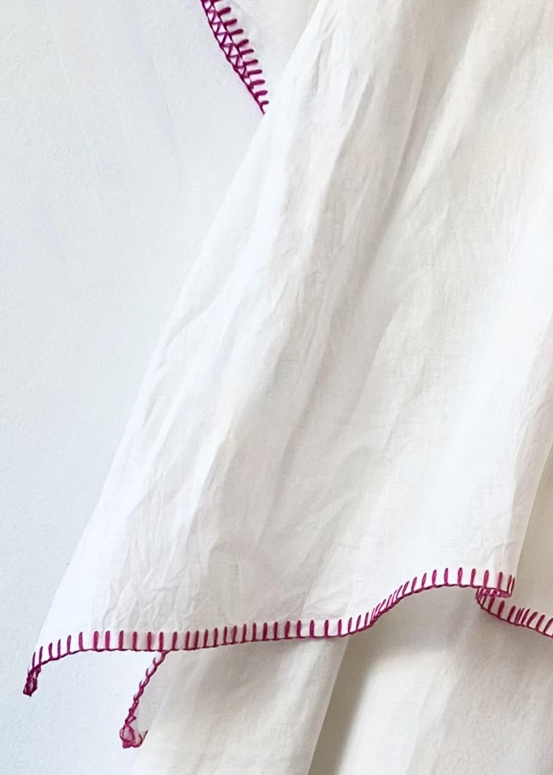 White fabric with red stitching on a light gray background