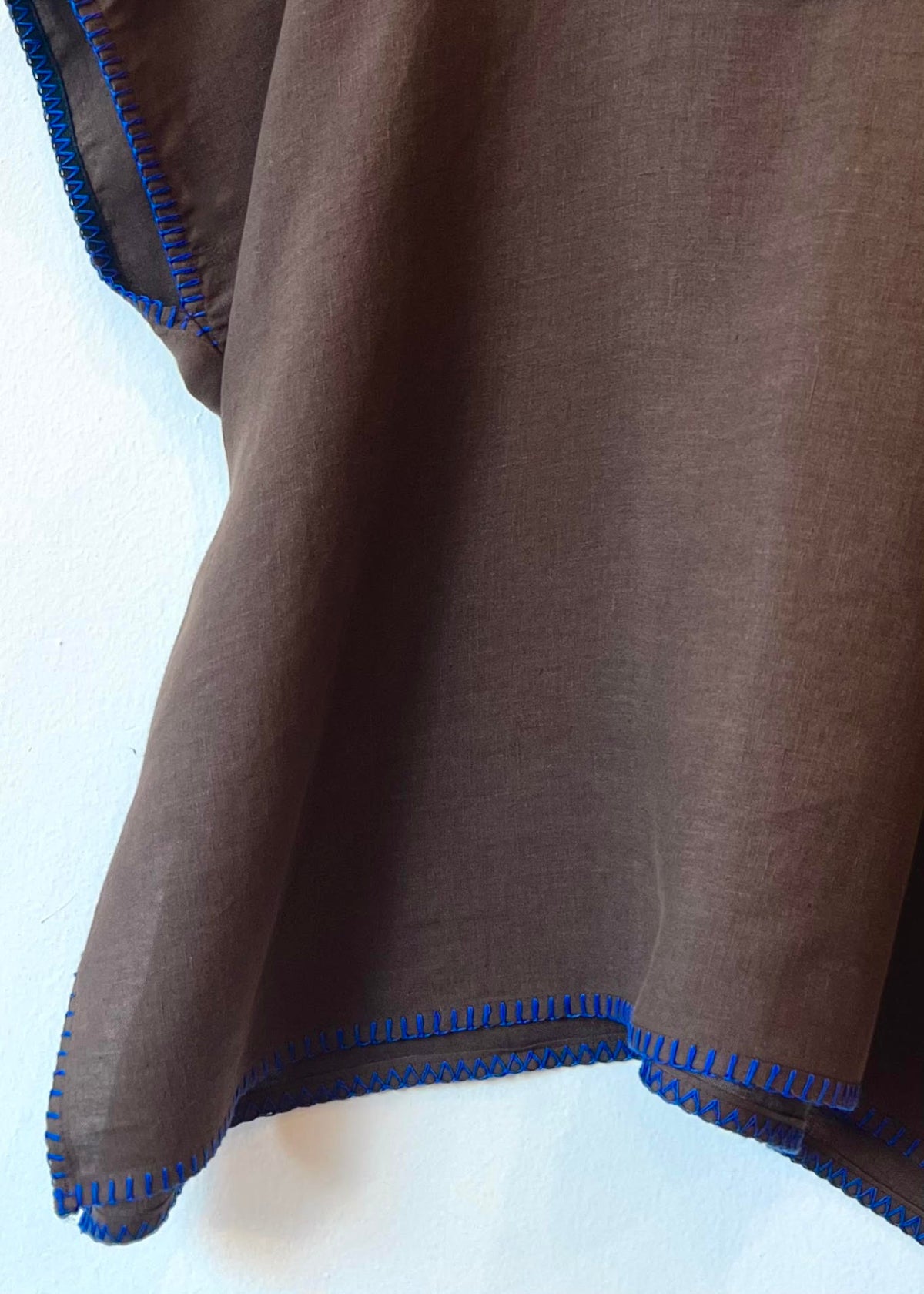 Brown fabric with blue trim on a white background