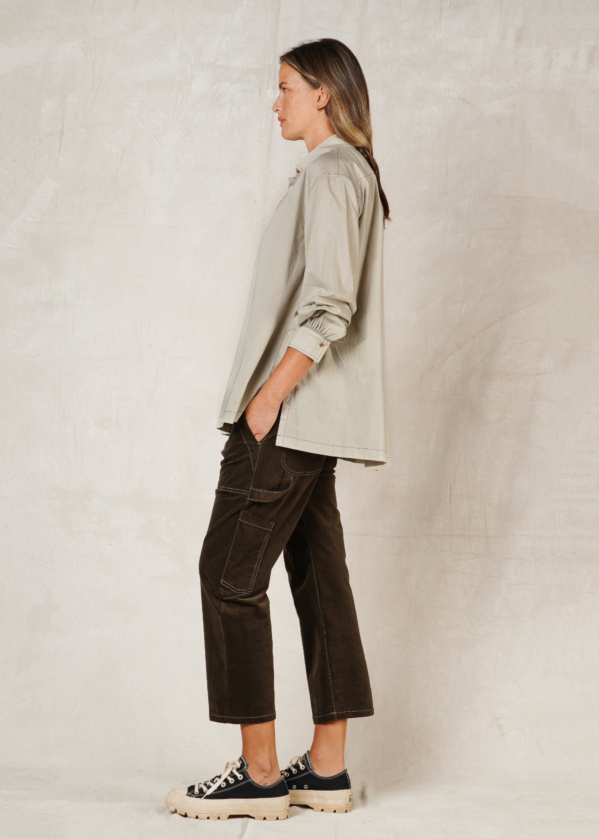 model in sea foam green button collar top with sleeves pushed up