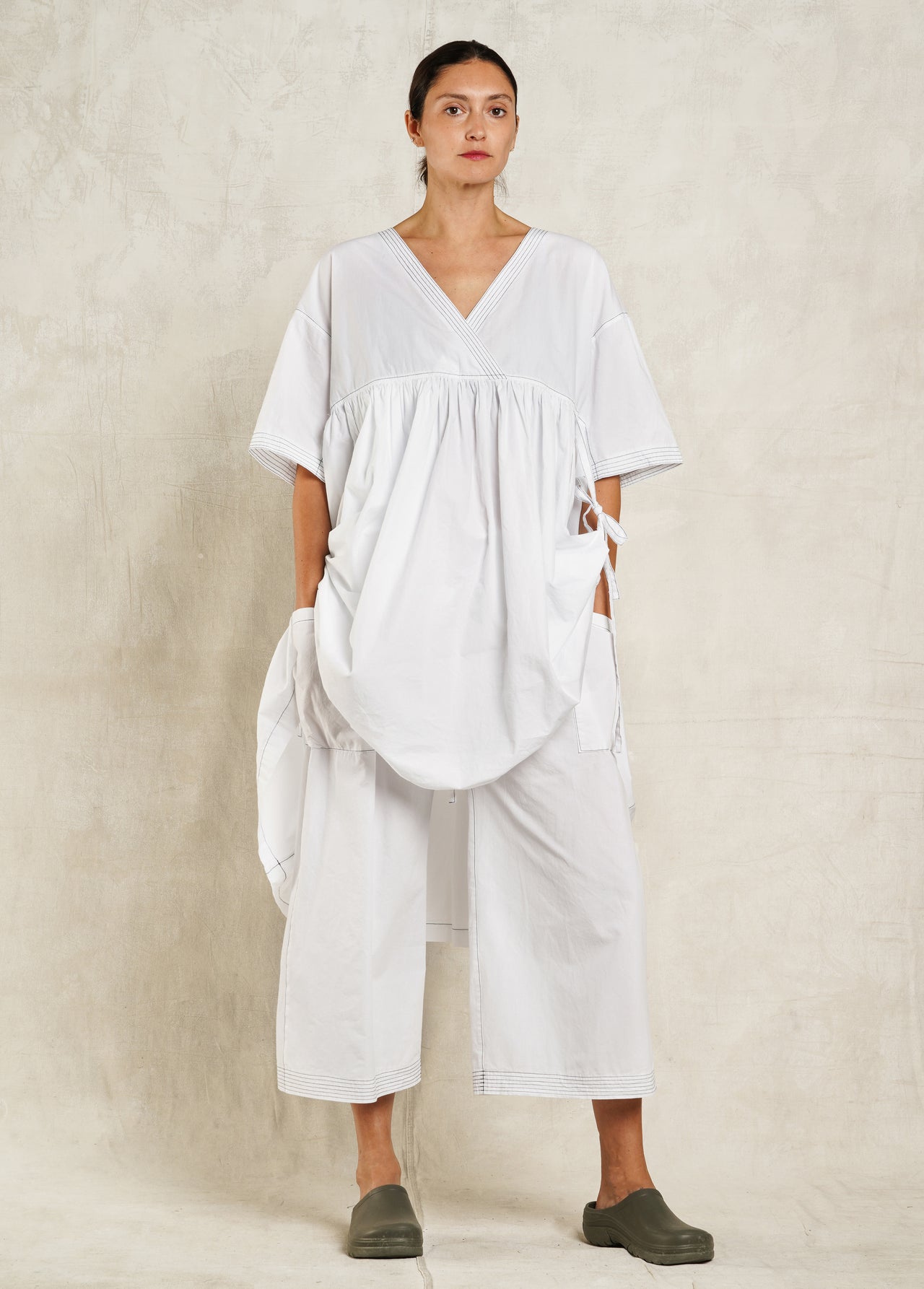 Woman wearing a white dress with a plain background