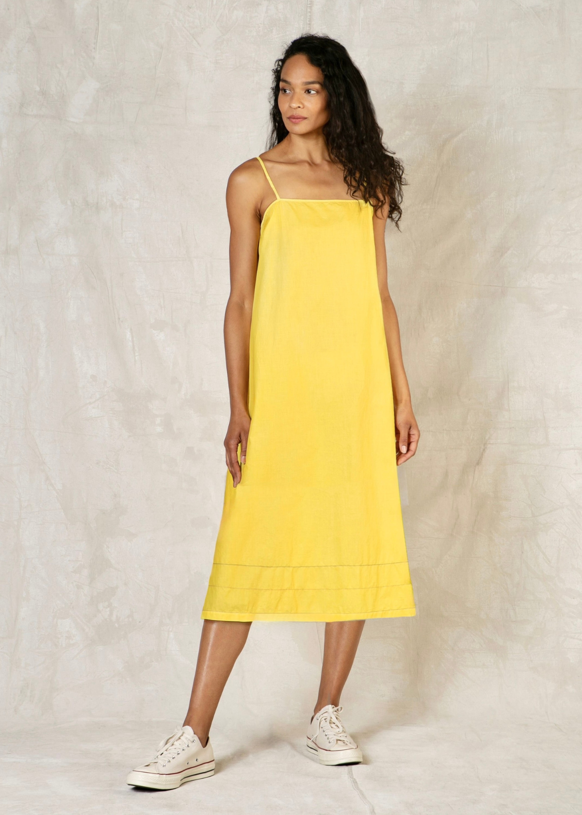 Woman wearing a peach dress against a plain background