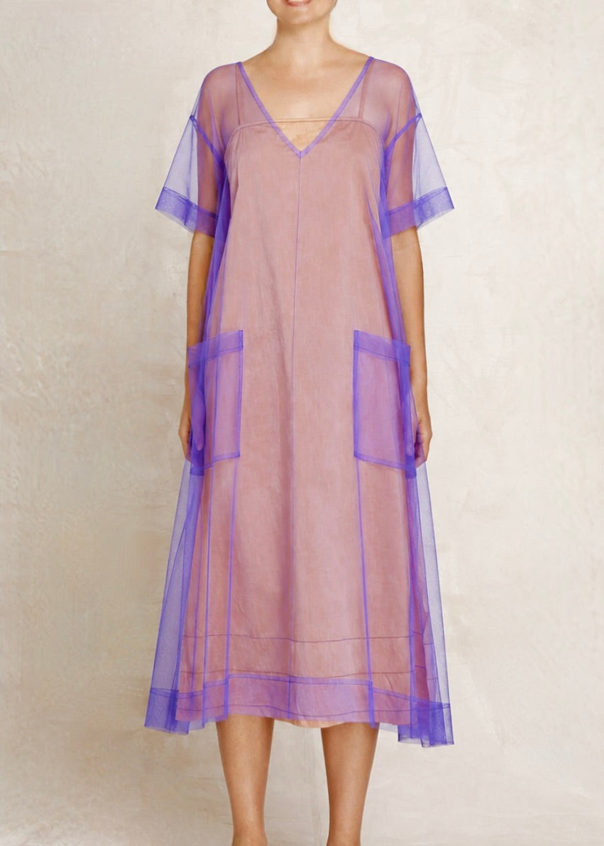Woman wearing a peach dress against a plain background