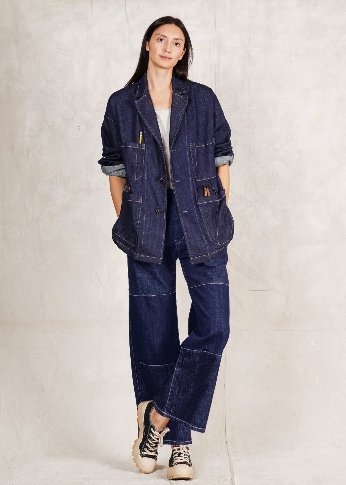 Person wearing a denim Worker's Jacket and Artist Pant indigo jeans on a plain background