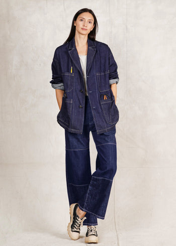 Person wearing a denim Worker's Jacket and Artist Pant indigo jeans on a plain background