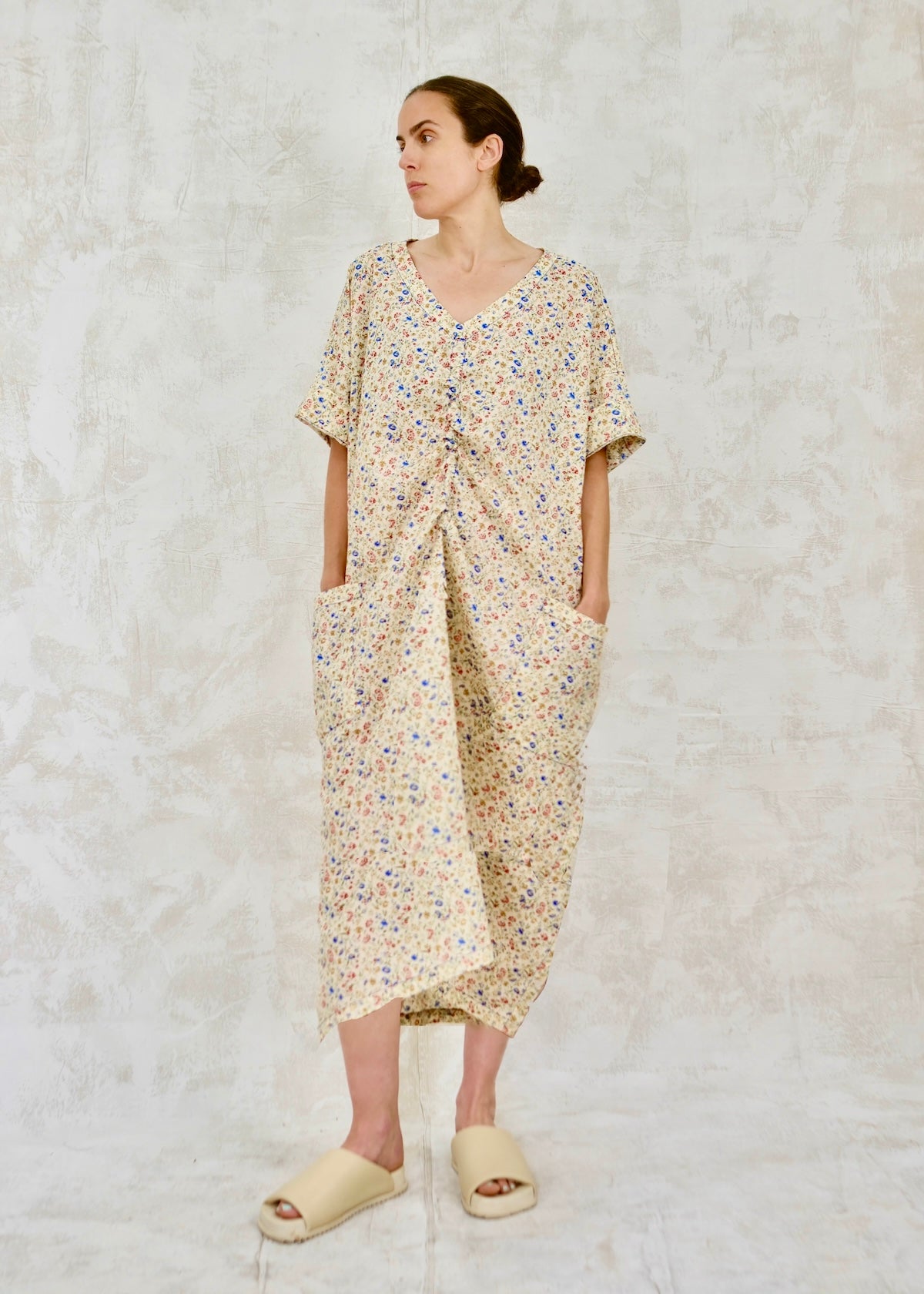 Woman wearing a floral dress against a textured white background