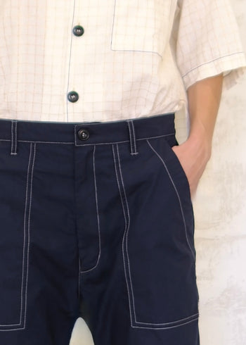 tight shot of navy poplin pants with contrast stitching button waist, pockets