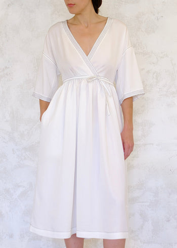 White dress with a belt on a textured white background