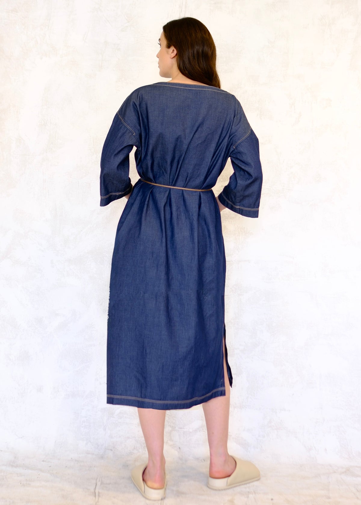 denim dress with cord belt and hands on hips rear view