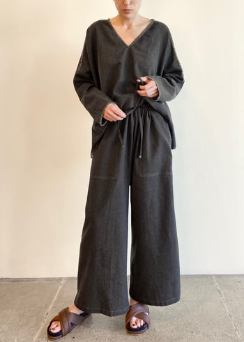 front view Charcoal Gray Flannel drawstring Picker's pants on a model with a gray flannel shirt with crochet stitching 