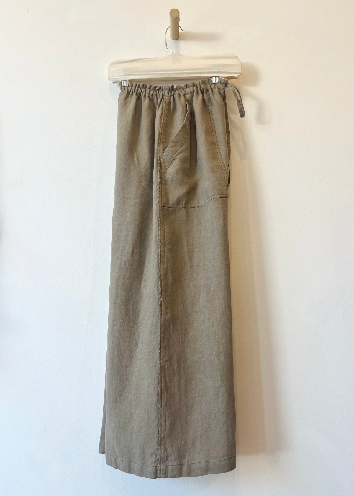 Brown pants on a hanger against a white background