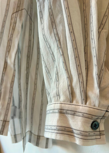 tight image of cuff detail of white shirt with black diamond stripes 