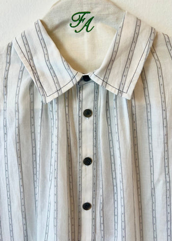 white shirt with black stripes collar with buttons on a hanger with brand initials FA 