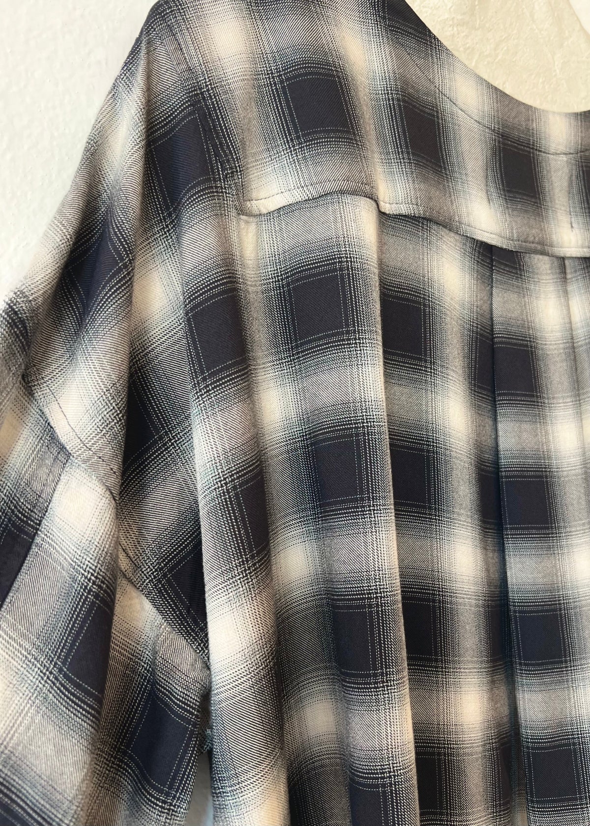 Close-up of a black and white plaid pattern fabric shoulder detail 
