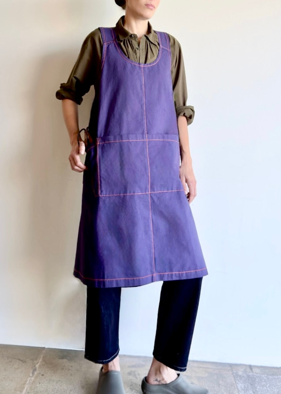 Model wearing Flora Animalia organic canvas harvest apron in purple grape, front.