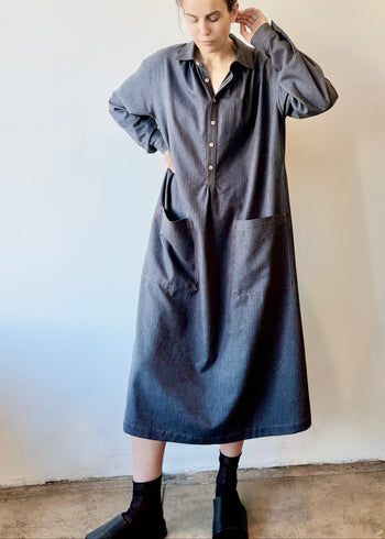 Person wearing a long gray Agnes dress against a plain background