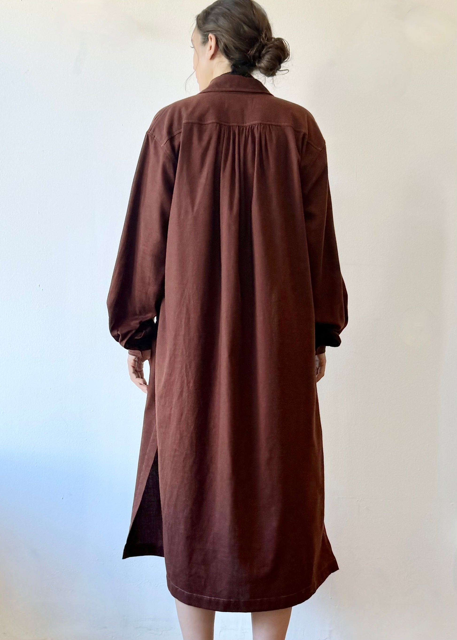 Rear view of model in burgundy dress against a white background