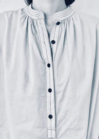 Close-up of a white shirt with black buttons on a person