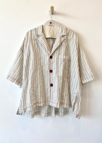 Striped shirt with buttons on a hanger against a white background