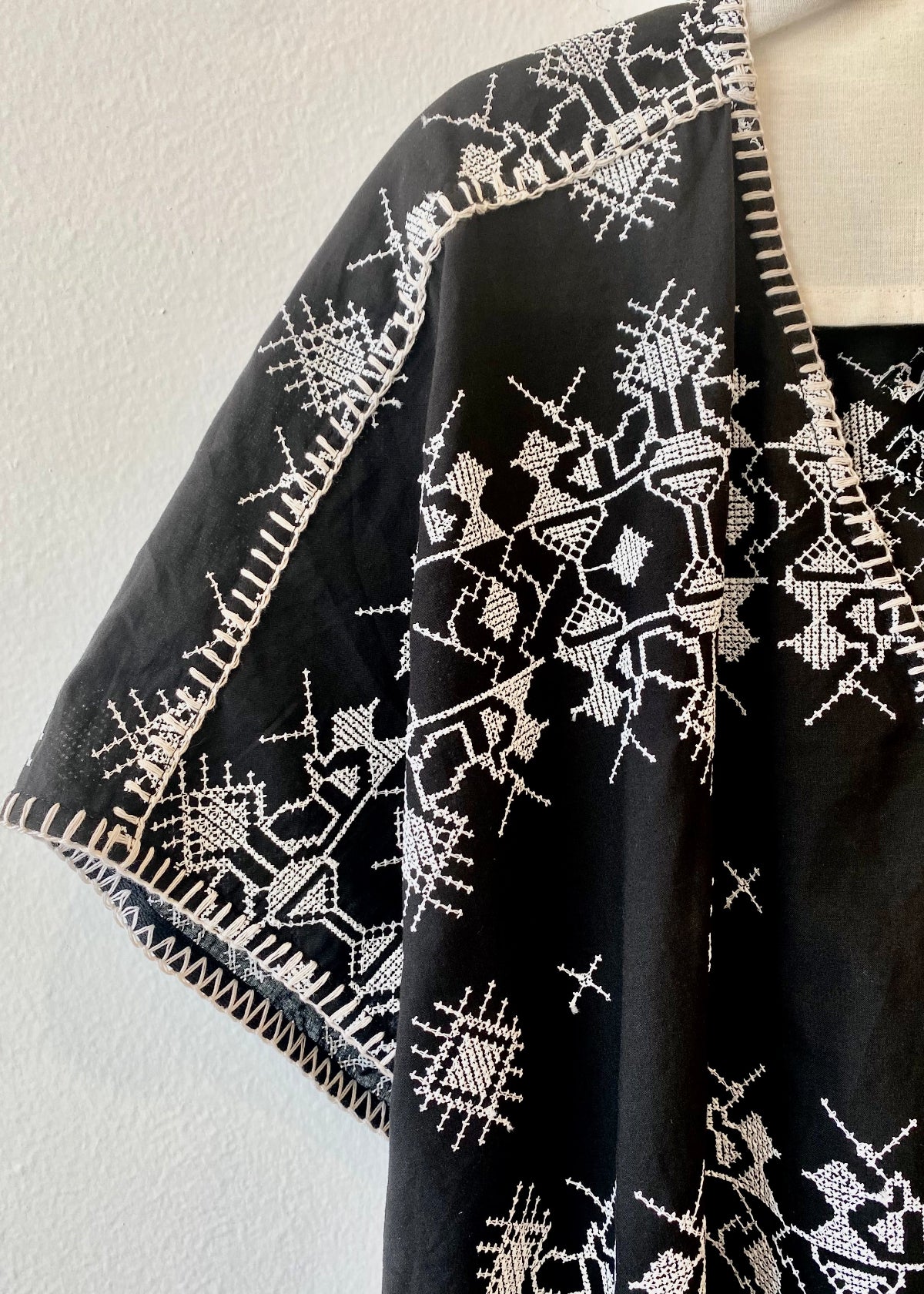 v-neck black caftan with white embroidery blanket stitch detail