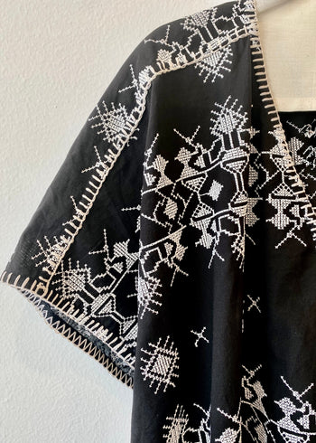 v-neck black caftan with white embroidery blanket stitch detail