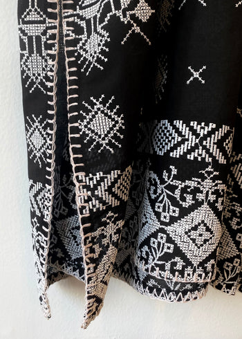 Hem ofblack caftan with white embroidery blanket stitch detail
