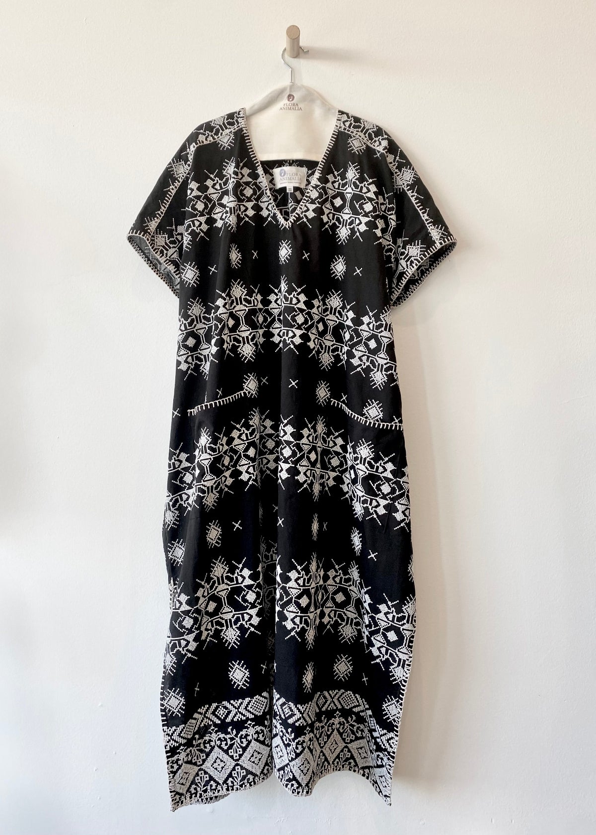 v-neck black caftan with white embroidery and blanket stitch edge front view