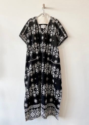 v-neck black caftan with white embroidery and blanket stitch edge front view